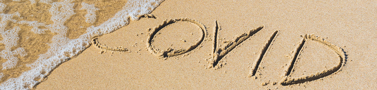 COVID written in sand on beach