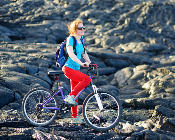 Woman Cycling On Lava Field On Hawaii